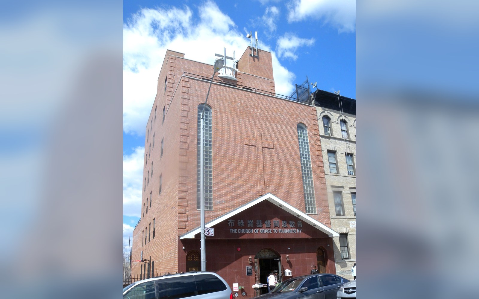 A brick church in Sunset Park with Chinese and English signage over the entrance
